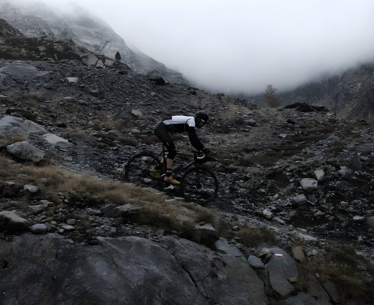 Rider on a Mason Bokeh gravel bike descends a rocky, mist-covered mountain slope.