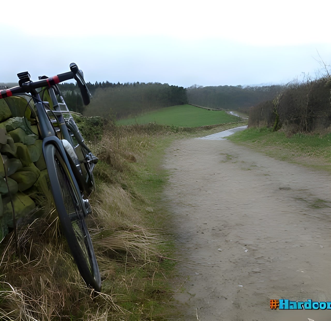 Hardcore 100 Peak District route: a drop-bar bike leaning on a dry-stone wall beside a stony track.