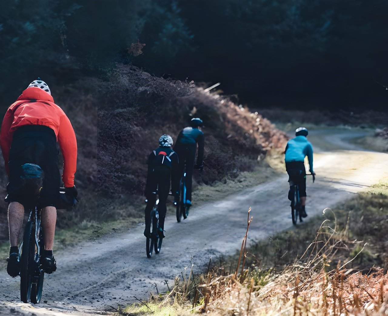 Four riders on a gravel forest road on the recon for The Distance, a bikepacking weekend in the Peak District.