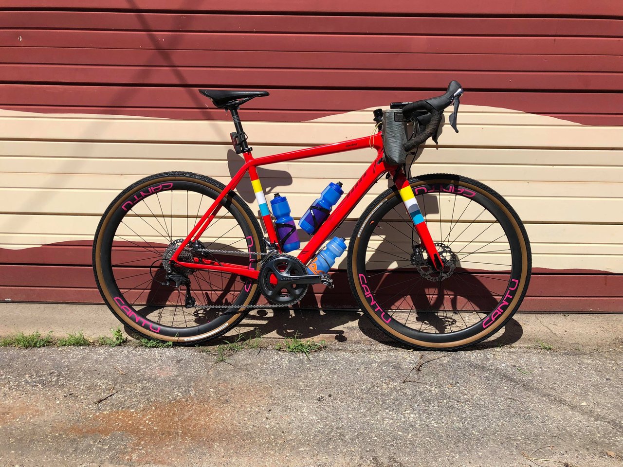 Paul Errington's red Salsa Warbird Carbon with Cantu carbon wheels against a wall before the Dirty Kanza 200.