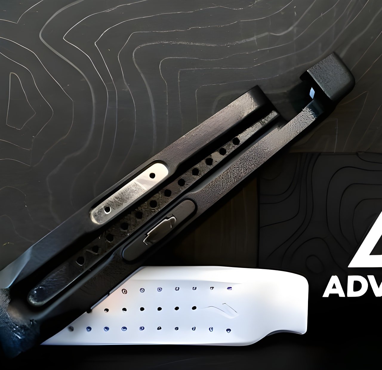 Black Specialized EMT tyre lever with its metal core laid across a white lever on a dark contour-patterned mat.