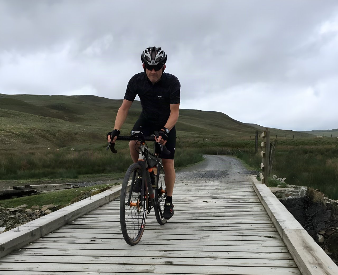 Rider crosses a wooden bridge on the Clearwen Dam gravel path during the This Is Not A Tour 400km Audax in Wales.