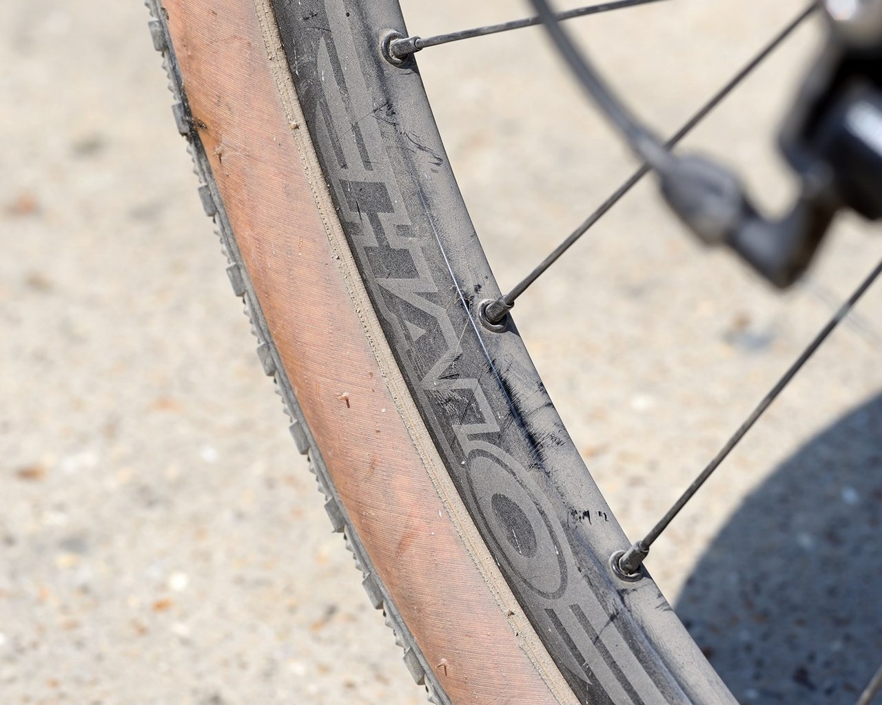 Halo Vapour GXC rim with the Halo logo and a tan-wall tyre on a sunlit gravel surface.