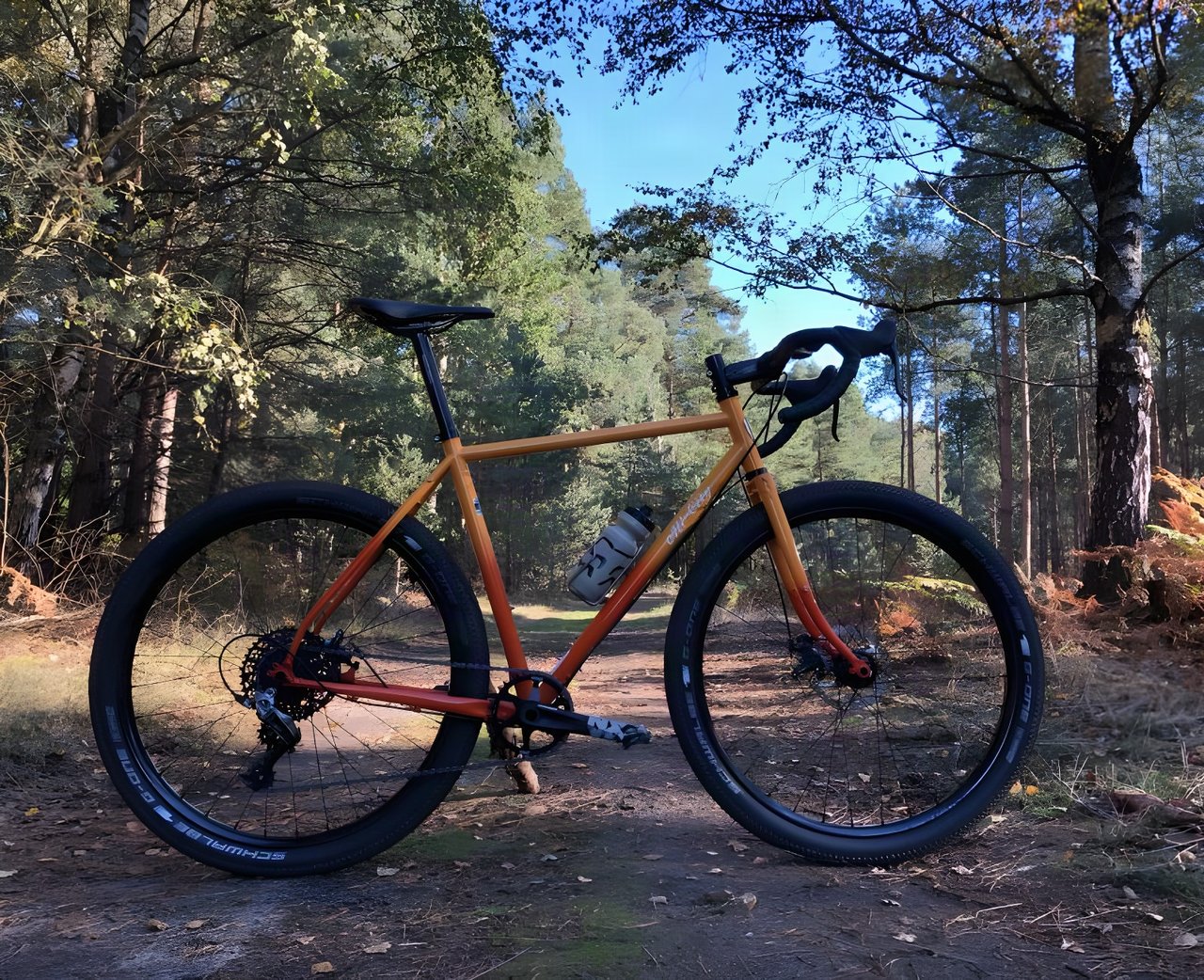 Orange All-City Gorilla Monsoon monster-cross bike with Schwalbe G-One tyres on a forest track.