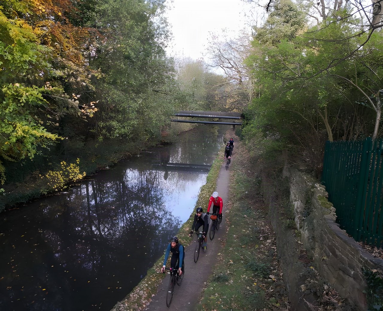Riders on gravel bikes follow a canal towpath on the Rapha Prestige Manchester ride.