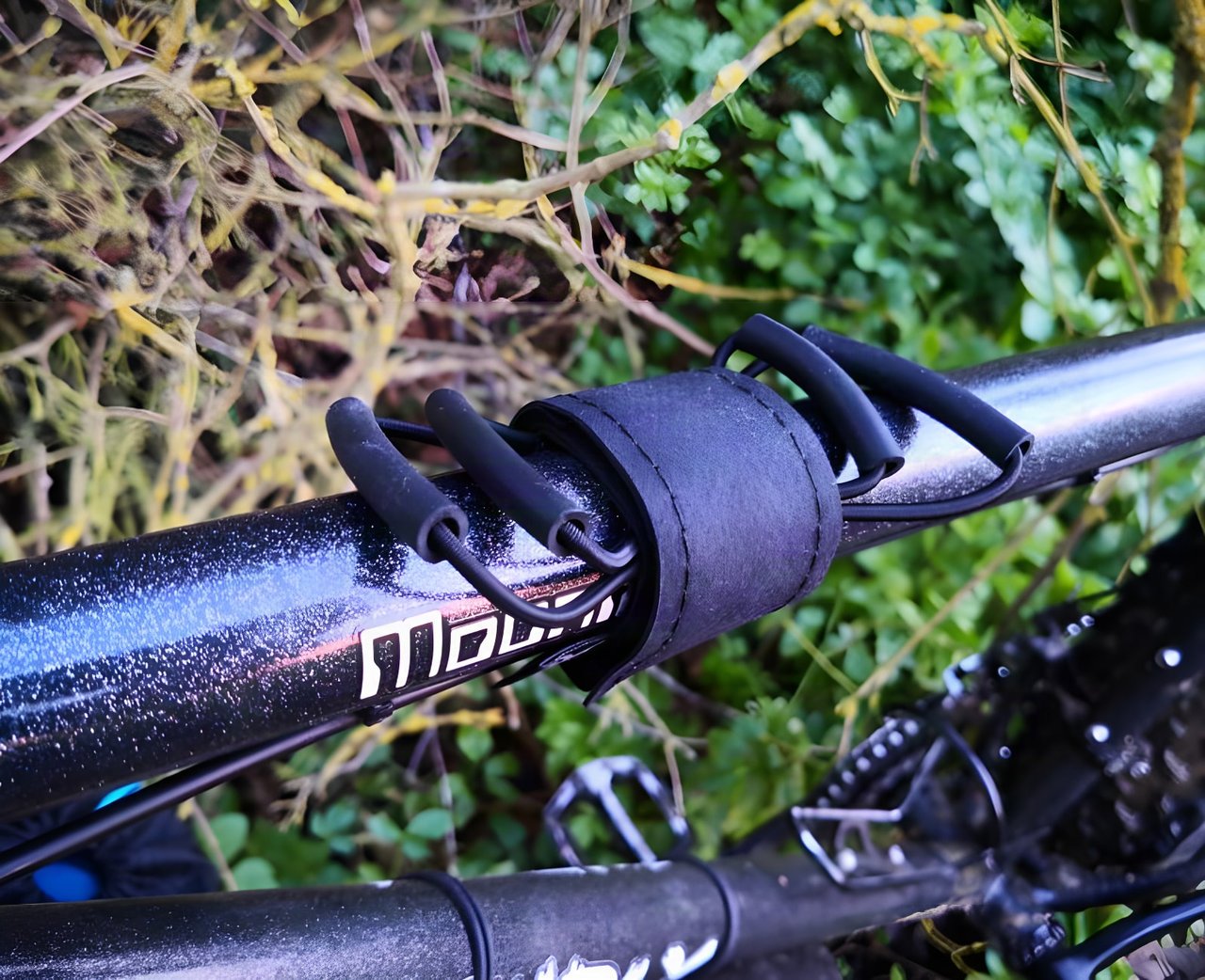 A Backcountry Research Super-8 strap fitted to a black top tube, its shock cord loops empty.