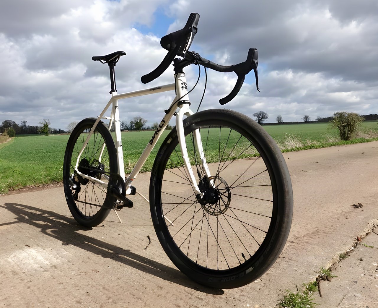 Surly Midnight Special 1x HRD in white with Schwalbe G-One tyres, seen low from the front on a farm track.