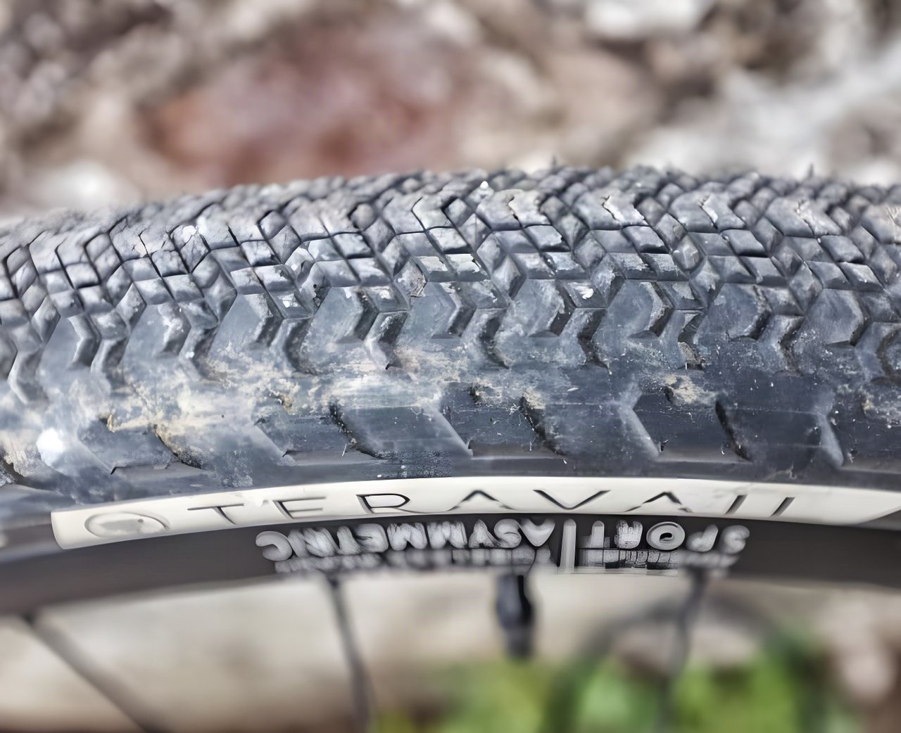 Close-up of the Teravail Cannonball 650b gravel tyre tread and sidewall logo, with dust in the diamond-shaped lugs.