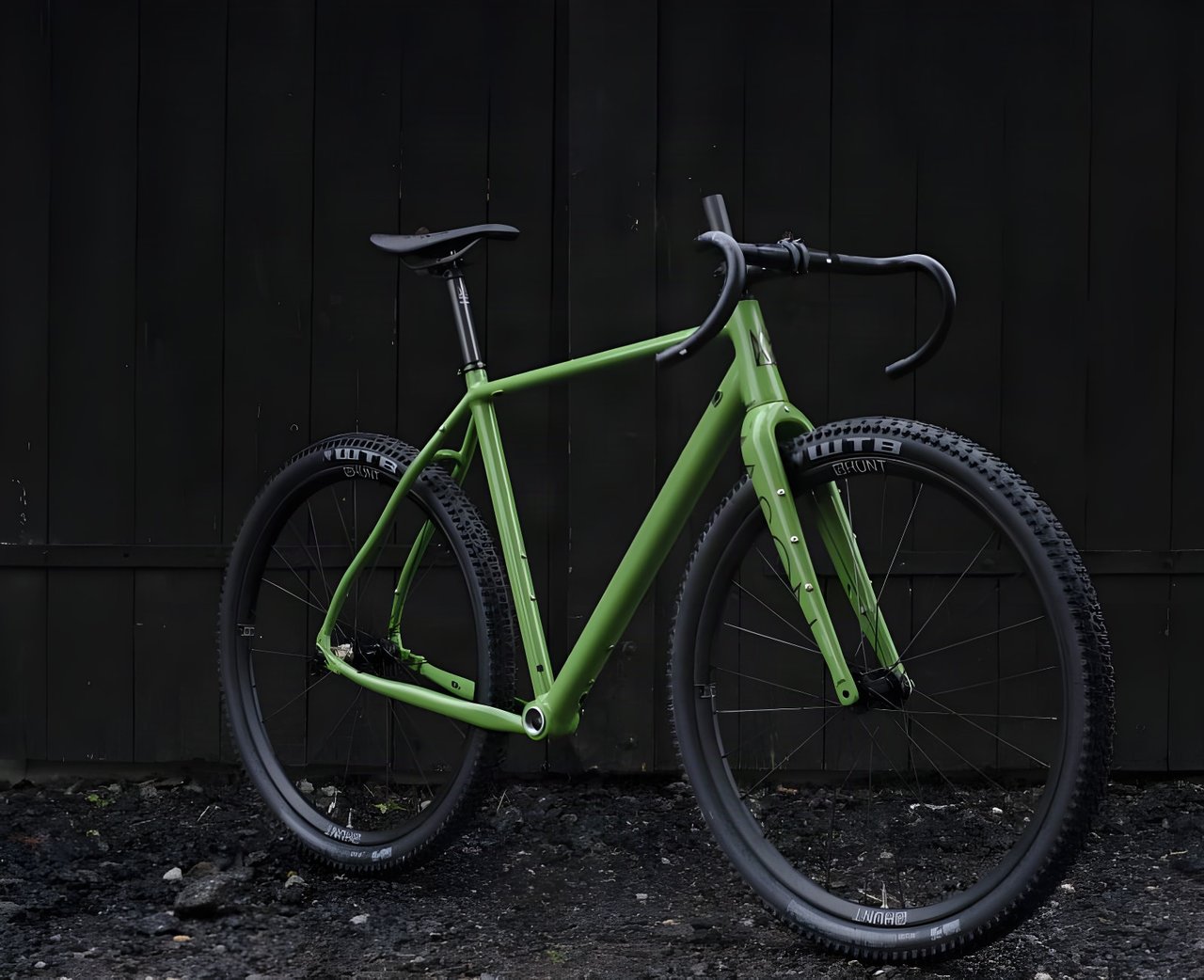 Mason Bokeh 2 in Filter Green with WTB tyres on Hunt wheels, leaning against a dark wooden wall.