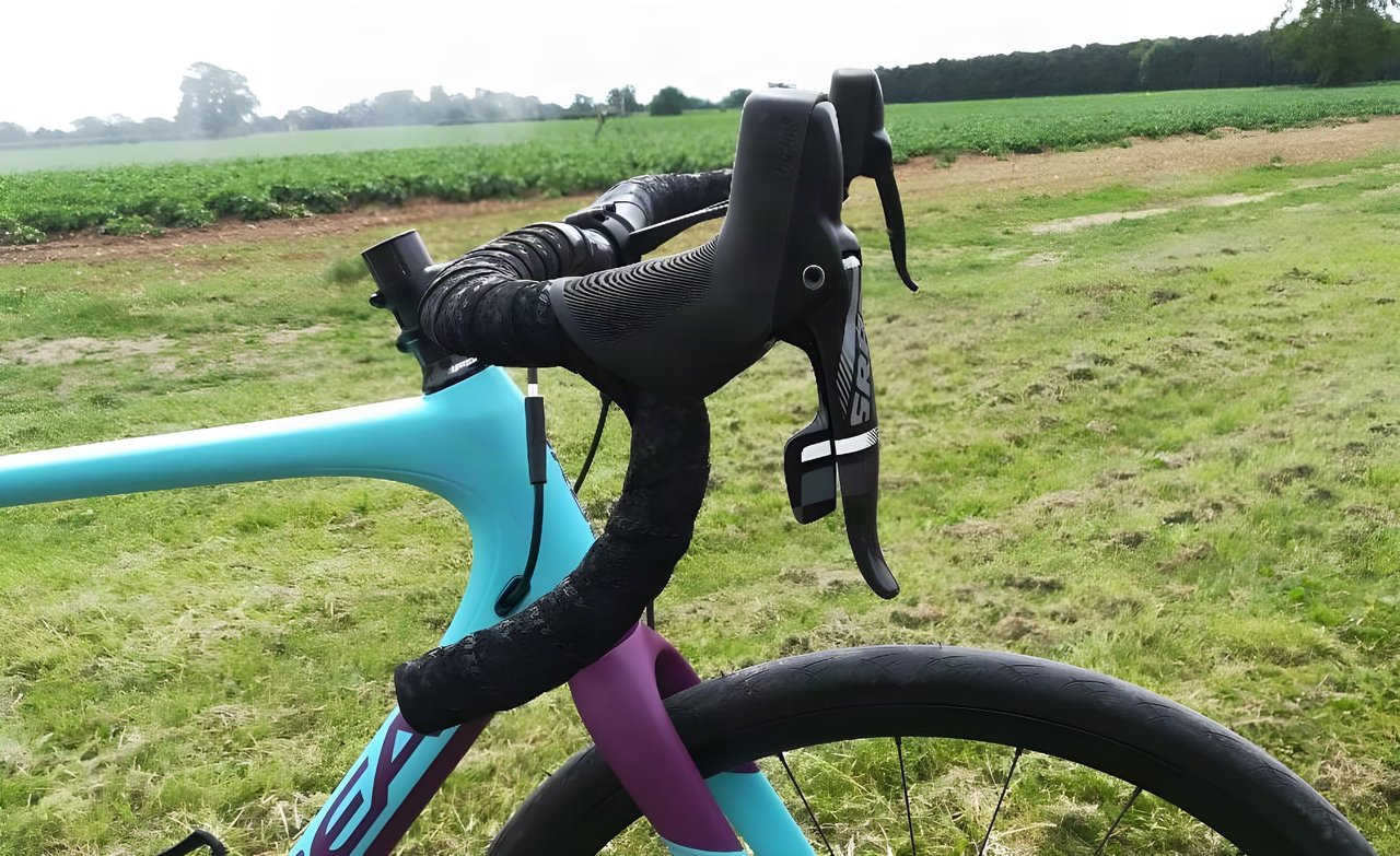 Ritchey WCS Ergomax road bar and SRAM lever on a turquoise Orbea, seen side-on in a field.