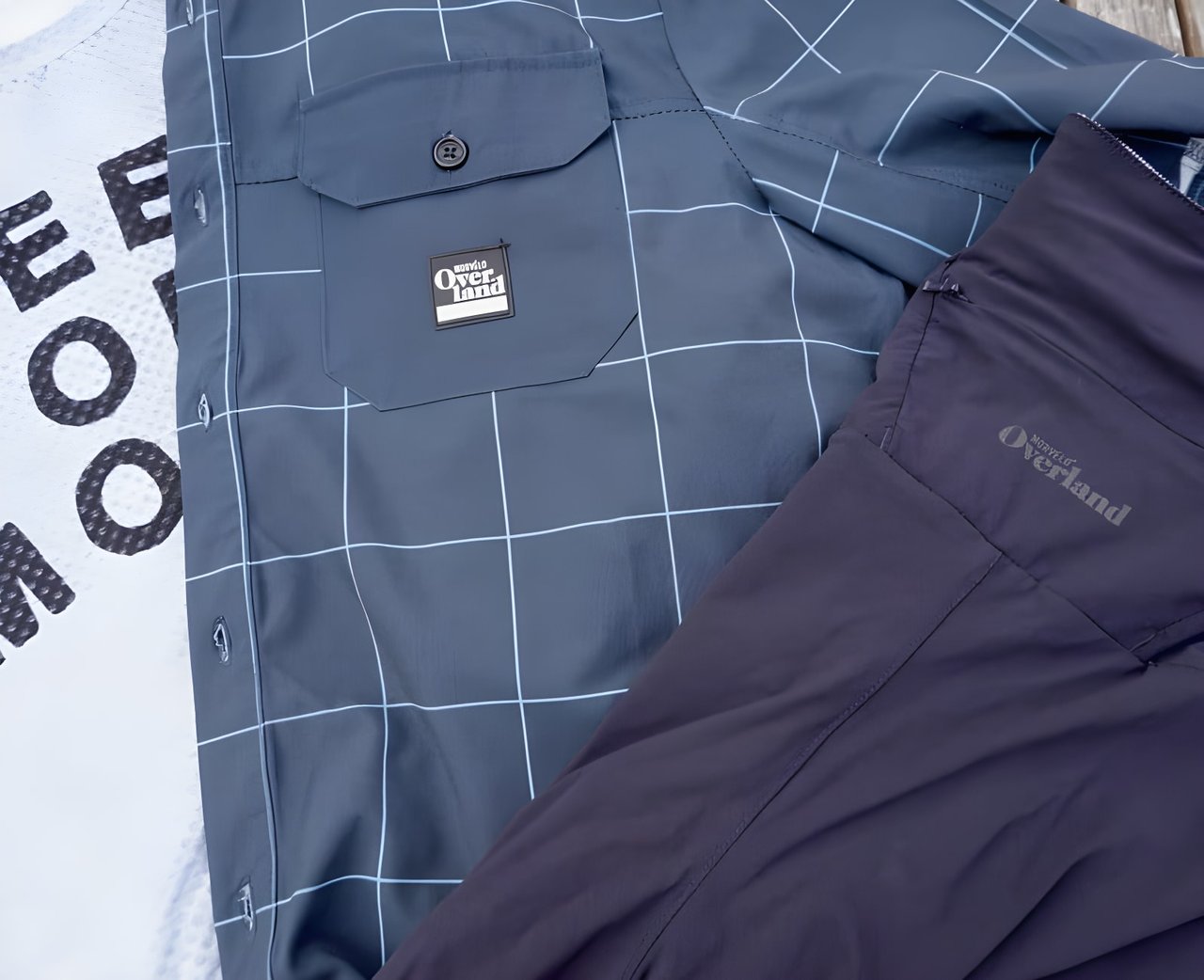 Morvelo Overland shirt with pocket badge, laid on a grey base layer and navy shorts.