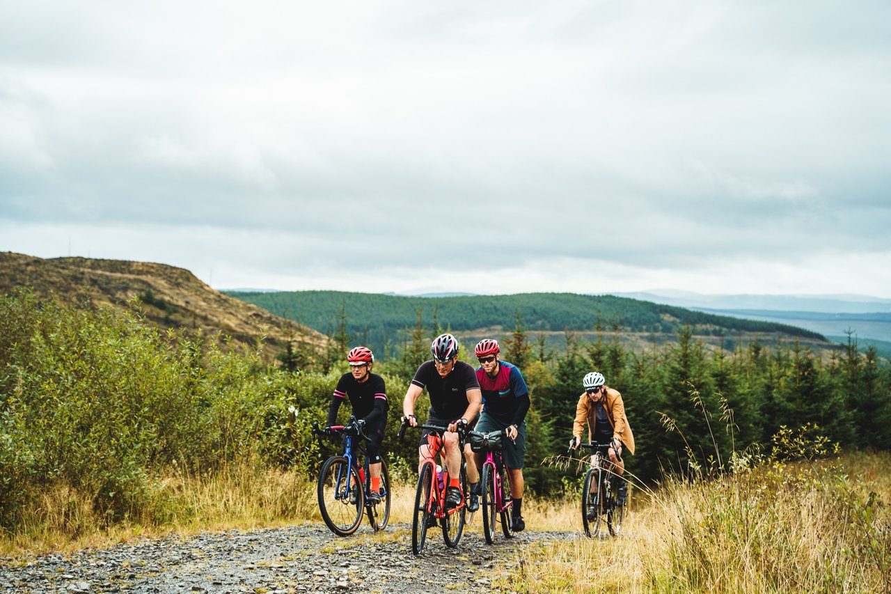 Four riders ride along a gravel forest track on the Frontier 300 route in the Scottish Borders.