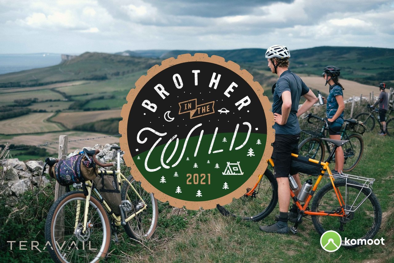 Brother in the Wild 2021 logo over riders and loaded bikes pausing on a hillside above the Dorset coast.