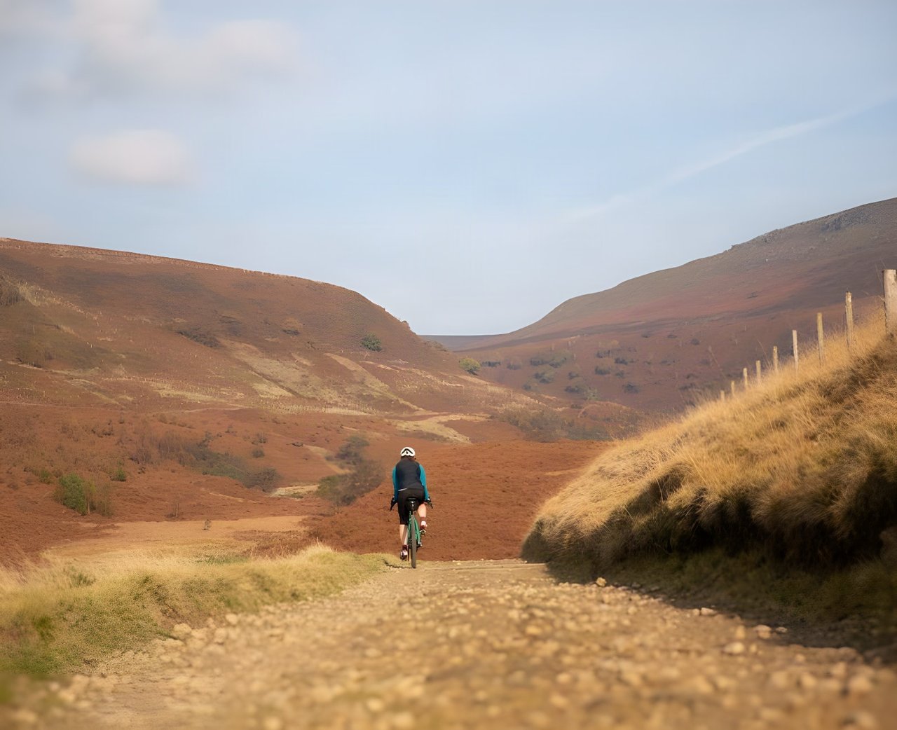 Gravel rider on a stony track through red-brown hills, promoting the Sonder Winter Gravel Series.