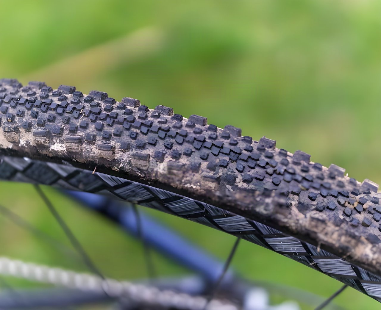 Mud-flecked WTB Raddler gravel tyre tread seen close up, with the knobbly side lugs in sharp focus.