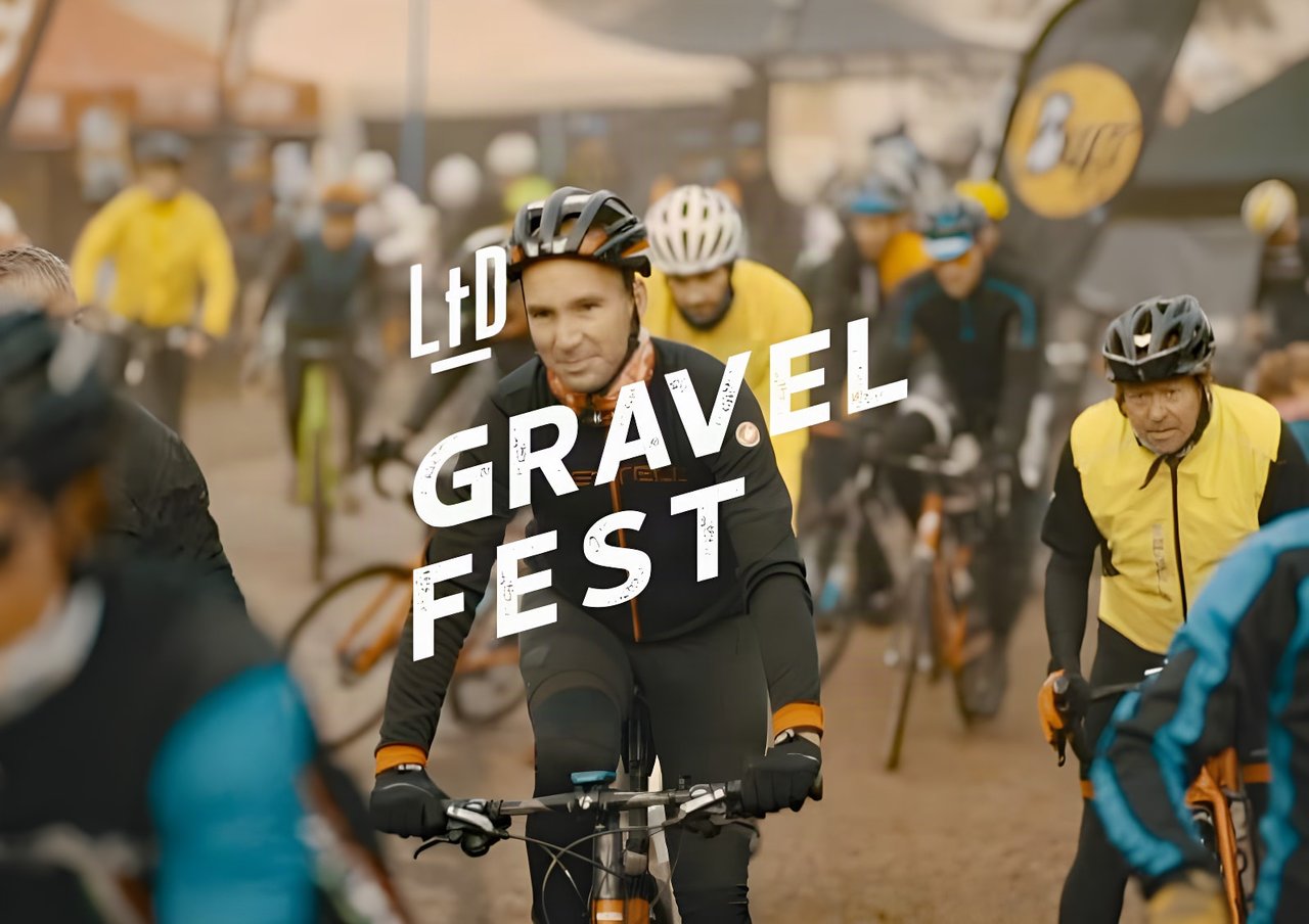 Riders at the LtD Gravel Fest in the Netherlands, with the event logo over the crowd.