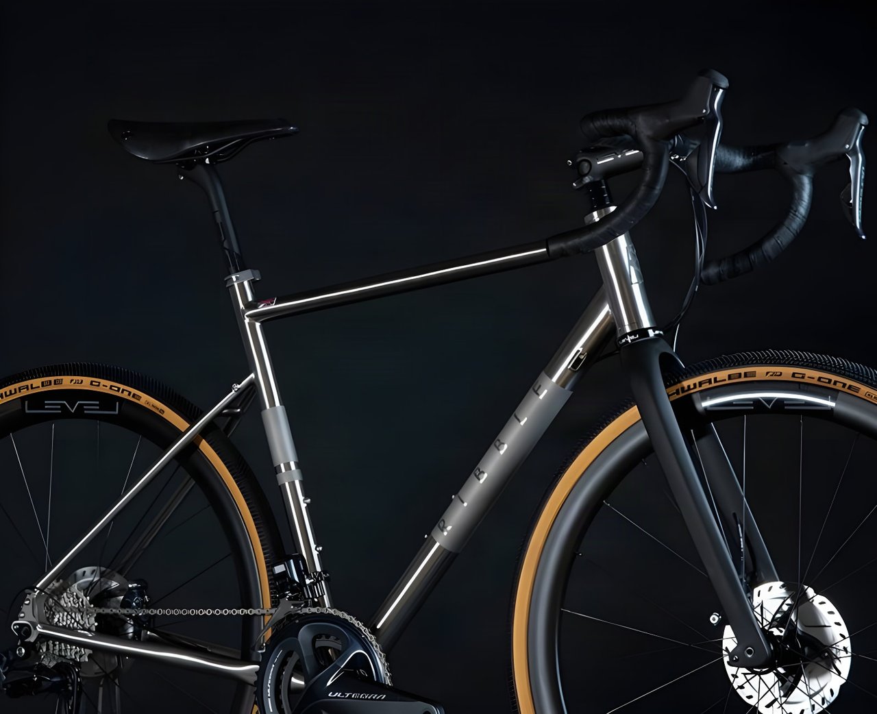 Ribble CGR Ti titanium gravel bike with Shimano Ultegra and tan-wall Schwalbe G-One tyres against a black backdrop.