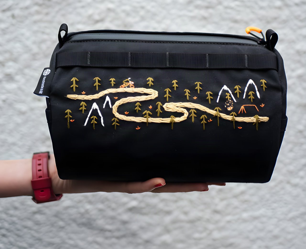 Wizard Works Get Wild Lil Presto! barrel bag in black waxed canvas with a hand-embroidered trail and mountains.