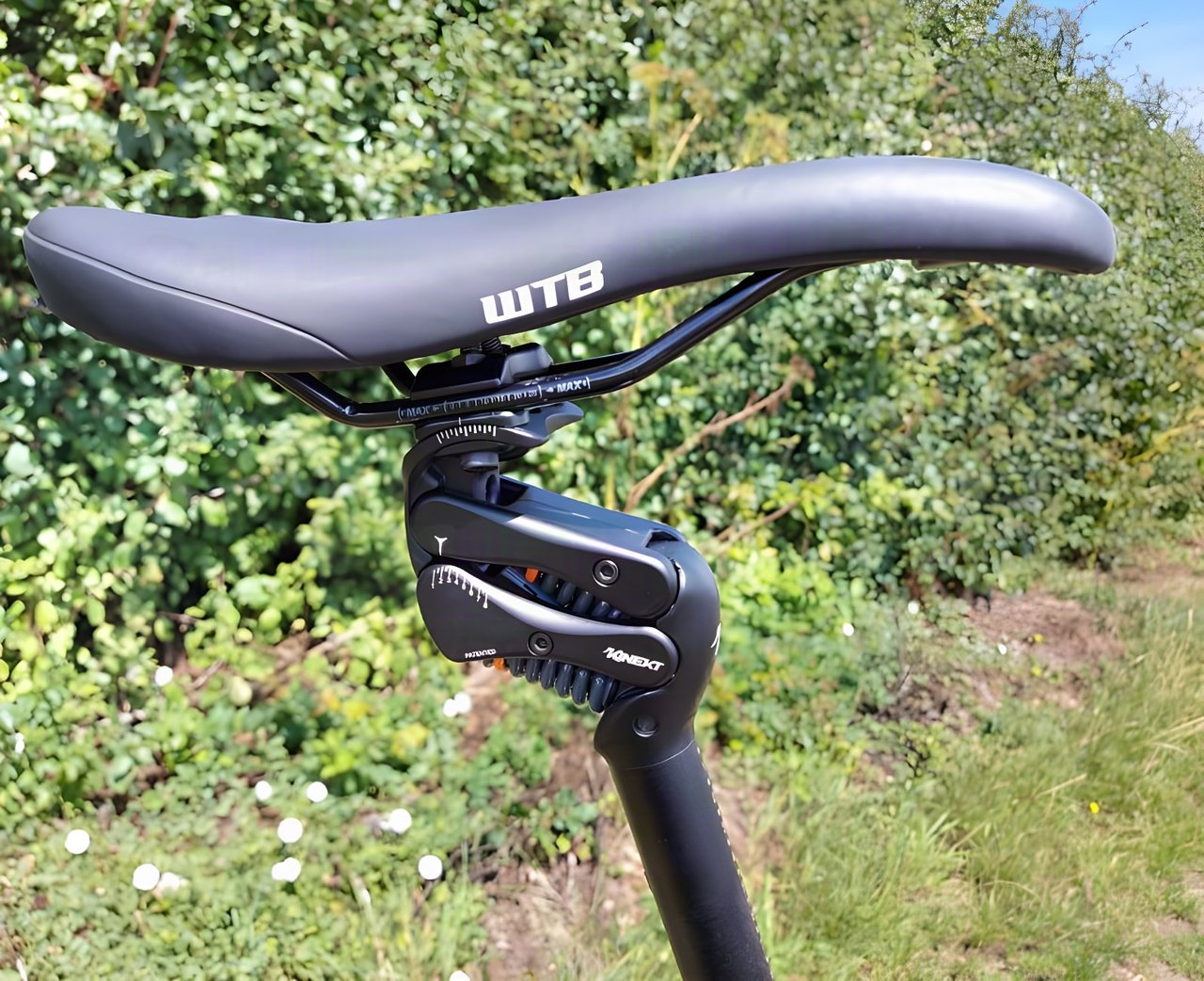 Cirrus Cycles Kinekt 2.1 suspension seatpost with its pivoting linkage and coil springs beneath a WTB saddle.