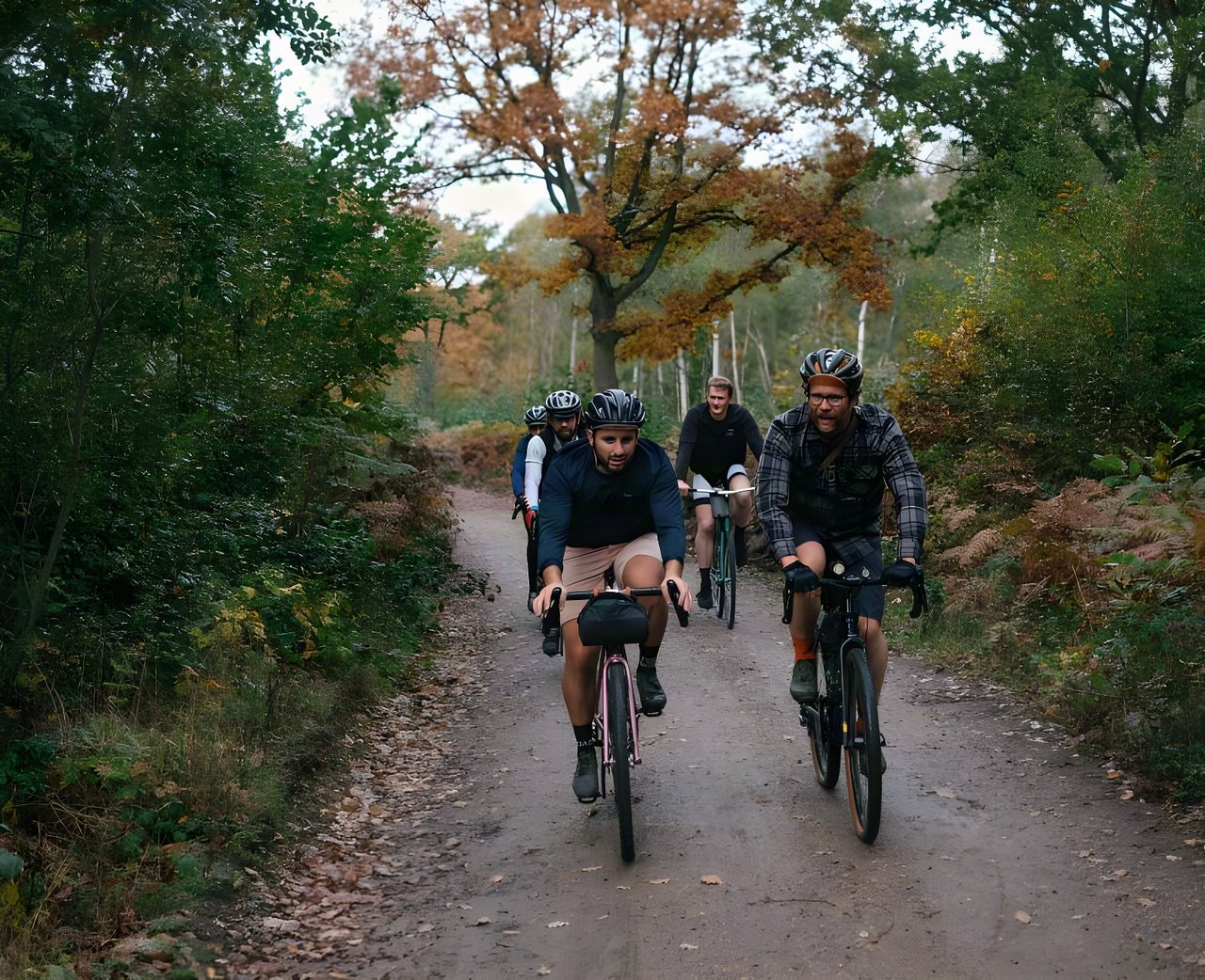 Group of riders on gravel bikes on a leaf-strewn woodland track during the Brother Cycles Kent gravel ride recce.