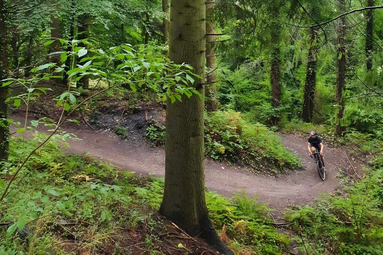 Rider rounds a bend on a wooded dirt trail on Dirty Devil's Fire and Brimstone ride in the Wye Valley.