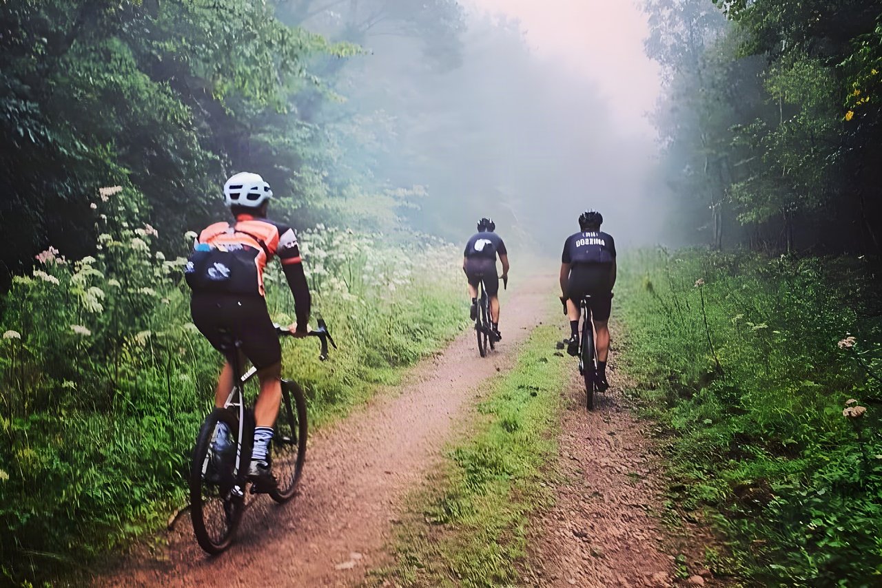 Three riders on a misty gravel track through Forest of Dean woodland on Dirty Devil's A Sunday in Hell ride.
