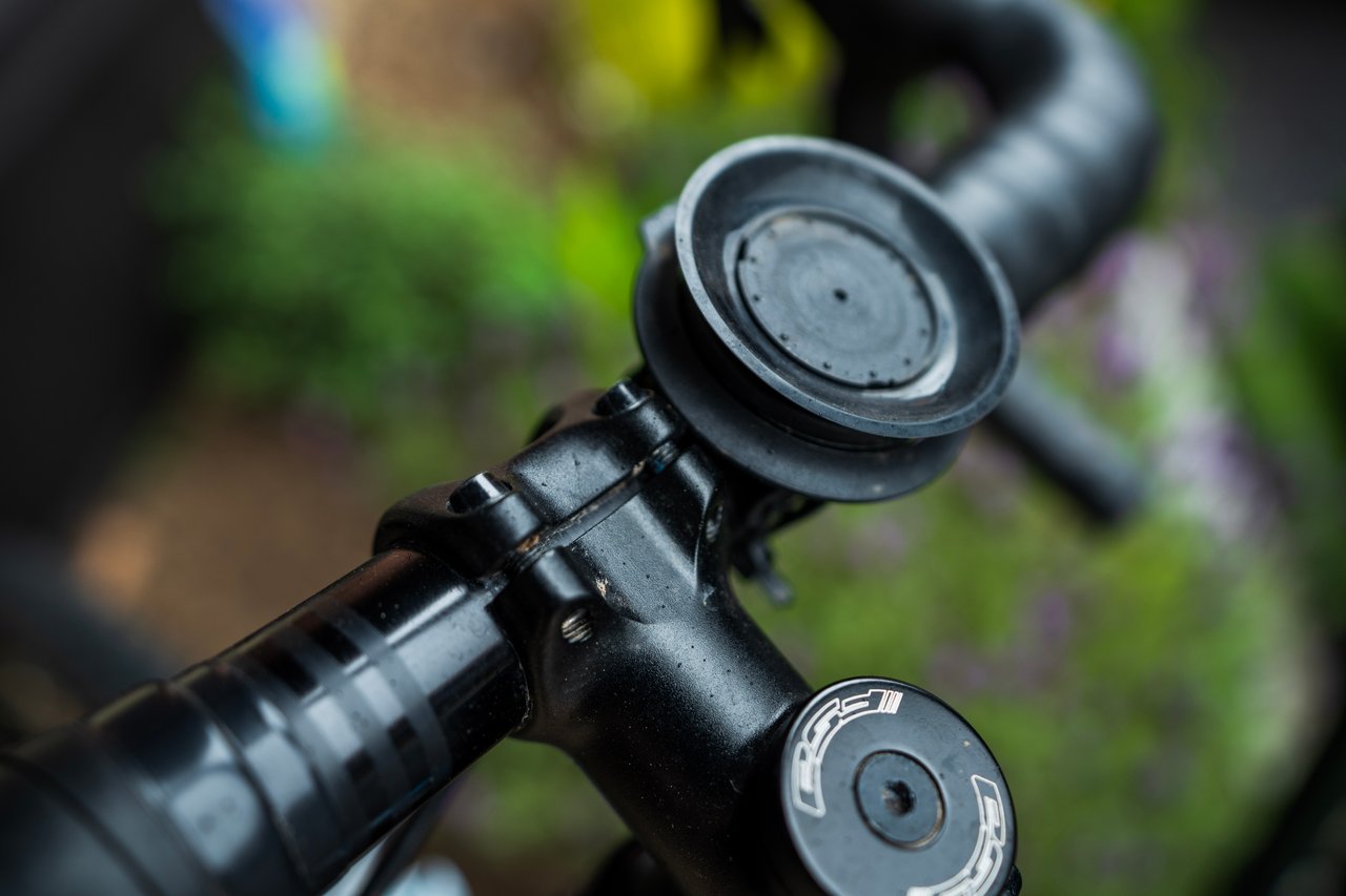 Fidlock VACUUM handlebar base clamped to a drop bar beside the stem of a gravel bike.