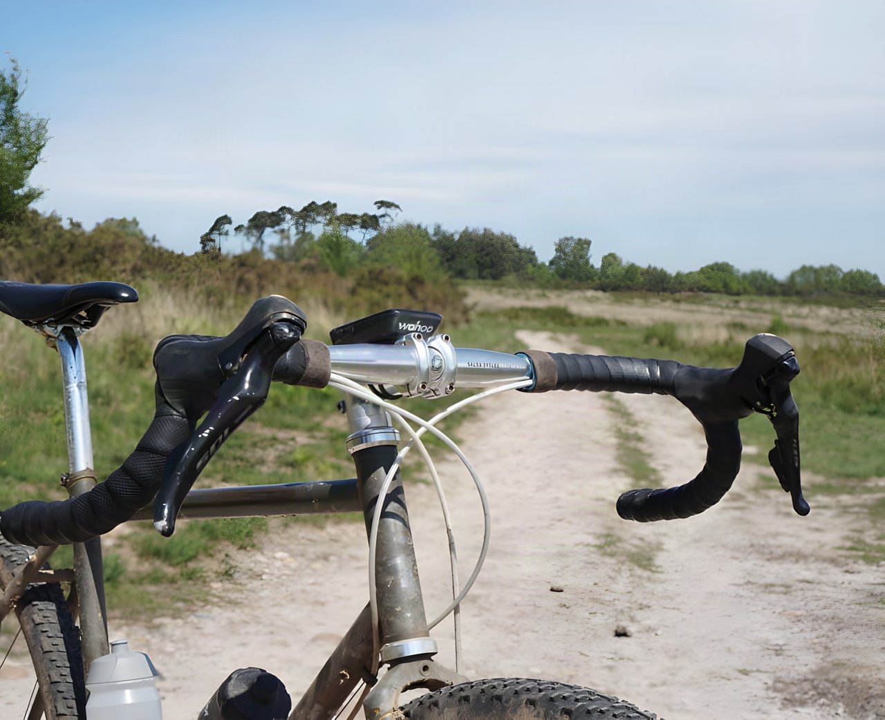 View over Salsa Cowchipper Deluxe 52cm bars with Wahoo computer, looking along a sandy gravel track in East Devon.