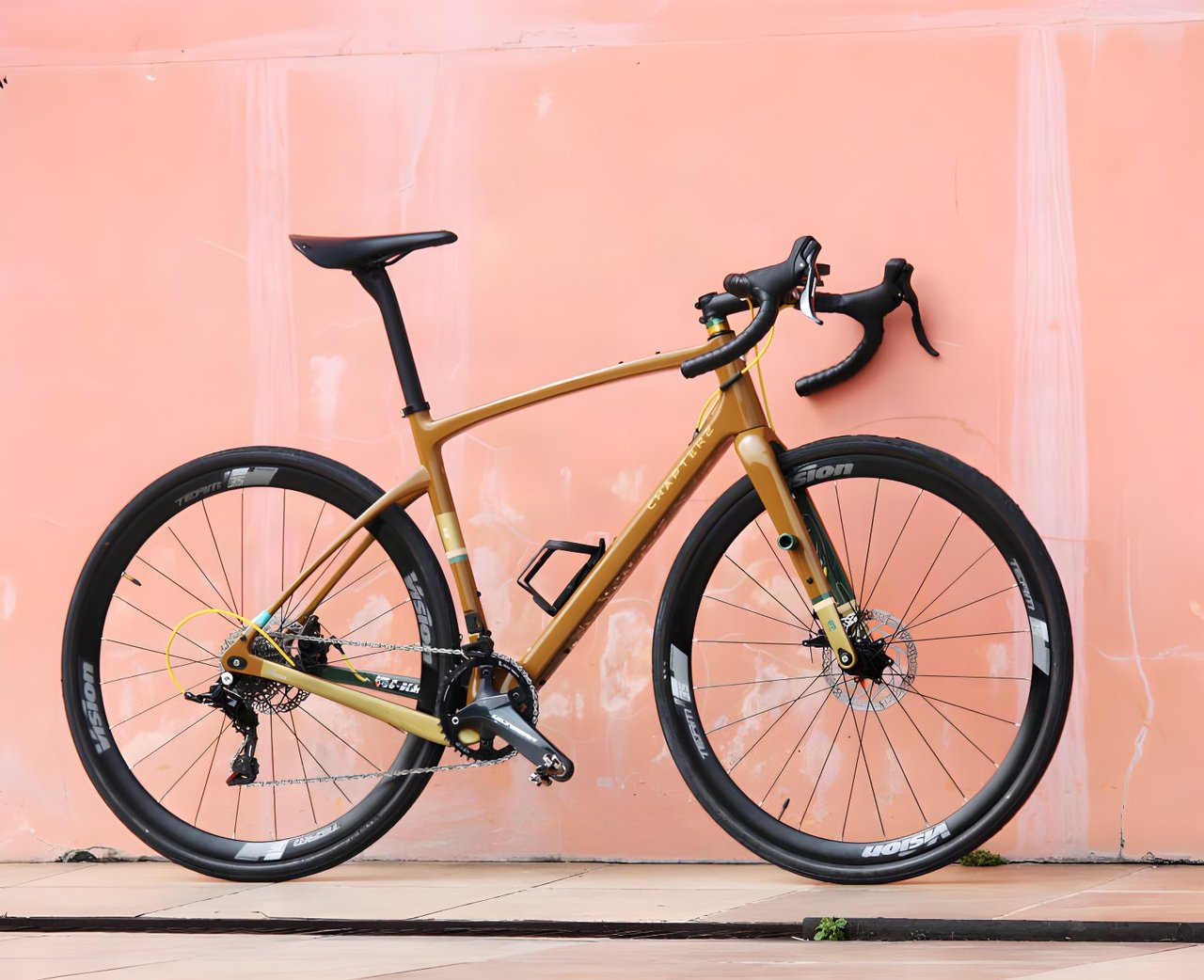 Chapter2 AO gravel bike in the bronze Earth Tones (Rangipo) finish leaning against a pink wall.