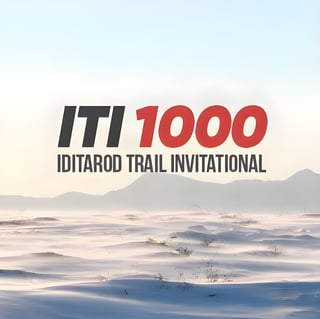 ITI 1000 Iditarod Trail Invitational logo over a pale, snow-covered plain and distant hills.