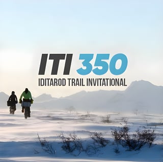 ITI 350 Iditarod Trail Invitational logo above two riders crossing wind-blown snow.