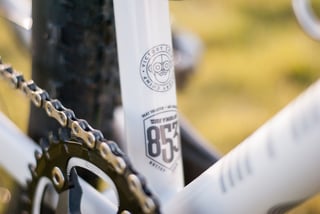 Close-up of the Reynolds 853 and Victory Chimp seat tube decals behind the Hope Retainer chainring and chain.