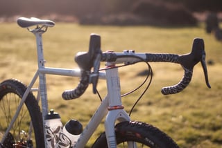 Handlebar and levers of the Donard x Victory Chimp bike, with two bottles in cages on the down tube behind.