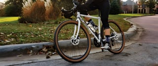 Surly Midnight Special with tan-wall tyres and disc brakes turning on a road beside a grassy kerb.