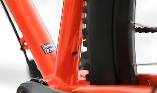 Close-up of the Gorilla Monsoon's orange seat tube where it meets the chainstays, with the rear tyre close alongside.