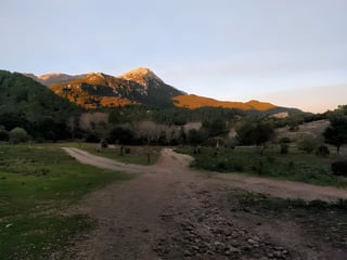 Tramuntana peaks catch the last light above a dirt-track junction on Bengt Feil's Mallorca MTB tour.