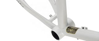 Close-up of the Surly Midnight Special bottom bracket shell and badge on the white steel frame.