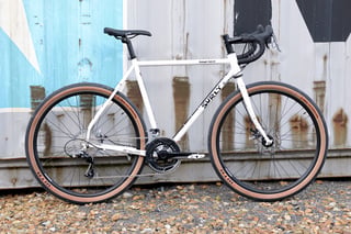 Steel Surly Midnight Special road-plus bike in white, side-on, with a flared drop bar and 650b wheels.