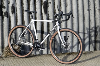 Surly Midnight Special angled towards the camera against a stained corrugated wall, drive side showing.