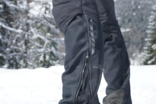 Gore Wear The One Primaloft trousers from the side, with outer lower-leg zip, in a snowy setting.