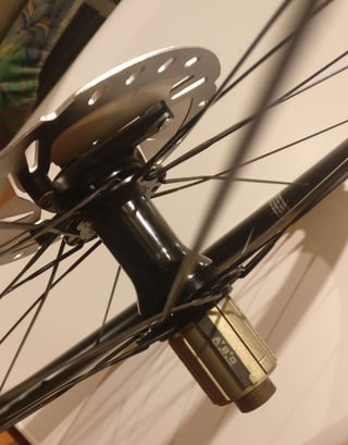 Angled close-up of a Hunt 30 Carbon Gravel hub showing the centre-lock rotor, spokes and freehub.