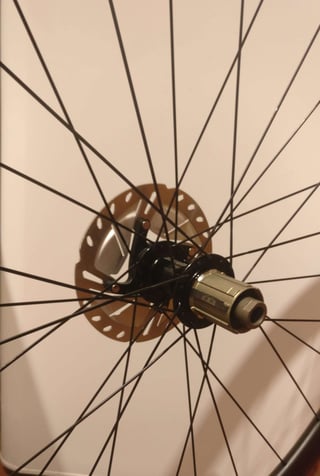 Rear hub of the Hunt 30 Carbon Gravel wheelset with centre-lock disc rotor, bladed spokes and freehub body.