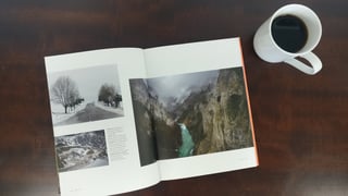 Escape By Bike open at a photo spread of a snowy tree-lined road and a turquoise river in a gorge.