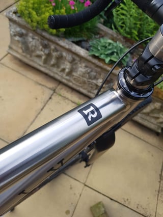 Reilly Gradient titanium top tube and headset seen from above, with the R logo and handlebar tape.
