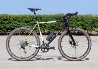 Side view of the All-City Cosmic Stallion steel gravel bike with Whisky carbon fork and 650b wheels on concrete.