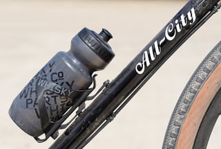 Whisky Parts Co bottle in a Whisky No.7 carbon cage on the Cosmic Stallion's down tube, on a Passport Cage Mover.
