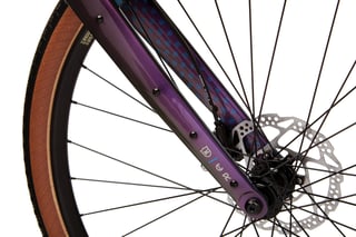 Kona Libre fork in purple with a front disc brake rotor, thru-axle and tan-wall tyre.