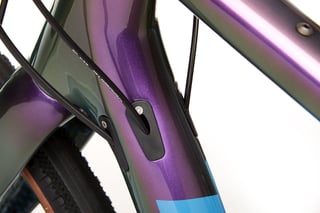 Kona Libre head tube in purple-green paint, with internal cable ports where the cables enter the frame.