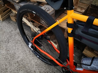 Rear end of the orange Gorilla Monsoon showing the Schwalbe G-One tyre, rear disc brake and cassette.