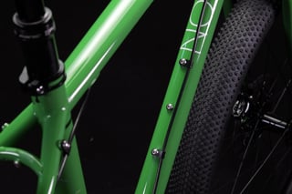Green Mason ISO frame close-up with seatpost, bottle bolts along the ISO-lettered down tube and a wide tyre behind.